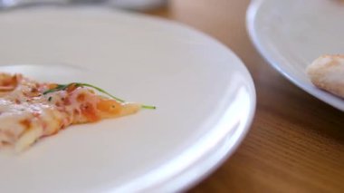 Lezzetli baharatlı peynirli taze pişmiş pizza dilimi. Siyah arka planda fırında pişirilmiş leziz İtalyan pizzası, dikey video. Yüksek kalite 4k görüntü