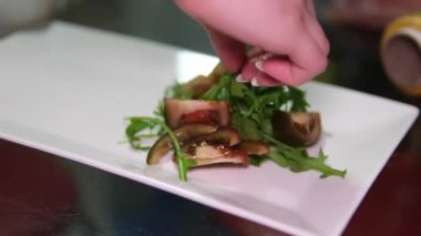 Kadınların elleri salatayı domatesli zeytinli domates, mozarella sebzesi ve roka ile karıştırır. Kolay bir diyet öğle yemeği ya da akşam yemeği için, sağlıklı dengeli bir yemek. Yüksek kalite 4k görüntü