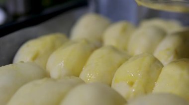 Otomatik taşıma bandındaki bir fırında ekmek üretimi için Hamur. Ekmek üretimi. Yiyecek endüstrisi. Yumurtalı tart.
