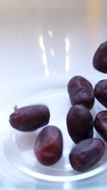 Kurumuş medikal jool günleri, tahta bir rattan kasesine dökülüyor. Arap tatlı ikramı. Ramazan yemekleri. Ağır çekim. Döndürme. Üst Manzara. Yüksek kalite 4k görüntü