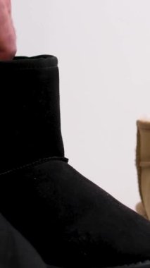 Sanatçı spor ayakkabılarına beyaz sıvı ayakkabı cilası sürüyor, bunu ince mor eldivenlerle yapıyor, cilalamayı derinin tüm yüzeyine uyguluyor. Yüksek kalite 4k görüntü