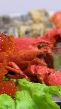 Beyaz tabakta deniz ürünleri suşisi, buzda kırmızı kerevit. Pişmiş soğuk kerevit. Kavanozda kırmızı havyar. Balık pazarında gösteri. Yüksek kalite 4k görüntü