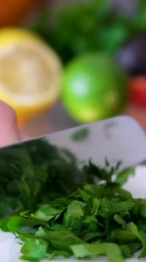 Cilantro maydanoz bıçağını yakın mesafeden kesiyor, şef kişniş aromalı kesiyor, geleneksel Asya mutfağı ve Meksika bitkisi stüdyosu fotoğrafı çekiyor. Yüksek kalite 4k görüntü