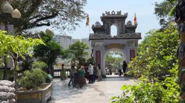 Turist gezileri farklı uluslara rehberlik eder. İnsanlar Mermer Dağ 'daki Budist tapınağını gezer. Buda tapınağının girişinin önünde. Da Nang, Vietnam 04.10.2025