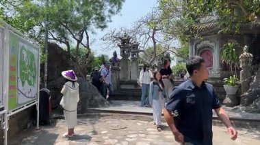 Turist gezileri farklı uluslara rehberlik eder. İnsanlar Mermer Dağ 'daki Budist tapınağını gezer. Buda tapınağının girişinin önünde. Da Nang, Vietnam 04.10.2025