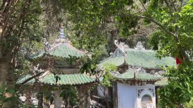 Bereketli yeşil tepeler ve uzaktaki kırsal manzarayla çevrili kayalık bir uçuruma tünemiş pagoda 'nın çarpıcı hava görüntüleri. Huzurlu sahne, doğal güzellikle kültürel mirası harmanlıyor..