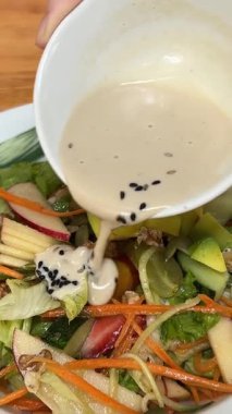 Taze sebzeli salata, canlı bir tat için üzerine sos dökülüyor. Yüksek kalite 4k görüntü