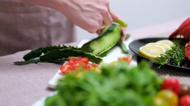 Tahta bir tahtanın üzerinde salatalık soyuyordum. Salatalık soyma videosu. Yüksek kalite 4k görüntü