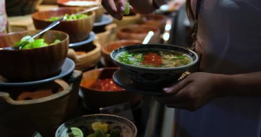 Sıcak bir kase Vietnam usulü tavuk çorbası, limonlu ve taze otlu. Bir kase çorbaya limon sıkıştır.