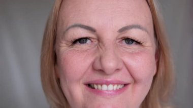 Gülümseyen kadın ya da kadın kameraya bakıp mutlu ve neşeli hissediyordu. Doğal olarak siyah tişörtlü kız beyaz arka planda izole edilmiş. Yakın plan. Yüksek kalite 4k görüntü