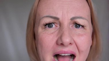 Beyaz tenli kadının inkar eden portresi dikkatle, eliyle ağzını kapatıyor, gördüğü şeyden korkuyor, korku ve korku hissediyor.. 