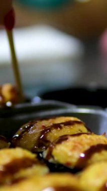 Yosun kaplı pirinç, yosun sarılı pirinç. Adamın eli, arkadaşına ya da mangal arkadaşına yumuşak kabuklu deniz yosununa sarılı pirinç toplamak için tahta çubuklar kullanır. Peynirli suşi.