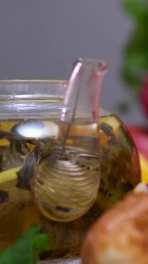 Meyve çayı ve yemek pişirmek için malzemelerle dolu bir çaydanlık. Kirazlı nane limon çayı.