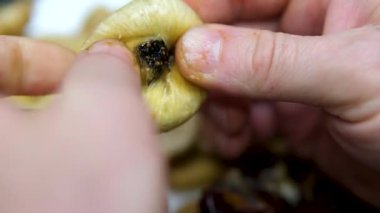 Kurumuş incir yığını ve beyaz bir tabağın üzerinde yarım meyve, dönüşümlü olarak gri arka planda yakın plan görüntüsü. Yüksek kalite 4k görüntü