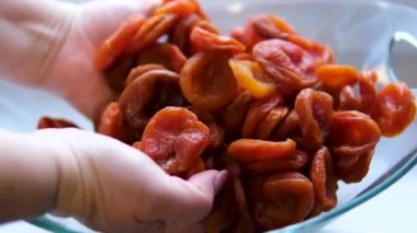 İki El, bir avuç dolusu kurutulmuş kayısıyı bir araya toplar. Dolly Slider aşırı yakın çekim. Yüksek kalite 4k görüntü