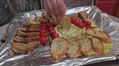 Fırından taze ve sıcak Camembert peyniri yavaş çekimde ekmeğe batırılıyor. Yüksek kalite 4k görüntü