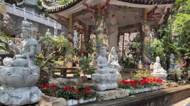 Bereketli yeşil tepeler ve uzaktaki kırsal manzarayla çevrili kayalık bir uçuruma tünemiş pagoda 'nın çarpıcı hava görüntüleri. Huzurlu sahne, doğal güzellikle kültürel mirası harmanlıyor..