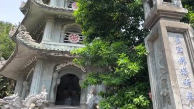 Bereketli yeşil tepeler ve uzaktaki kırsal manzarayla çevrili kayalık bir uçuruma tünemiş pagoda 'nın çarpıcı hava görüntüleri. Huzurlu sahne, doğal güzellikle kültürel mirası harmanlıyor..