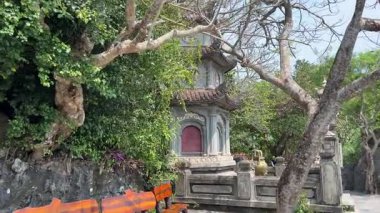 Bereketli yeşil tepeler ve uzaktaki kırsal manzarayla çevrili kayalık bir uçuruma tünemiş pagoda 'nın çarpıcı hava görüntüleri. Huzurlu sahne, doğal güzellikle kültürel mirası harmanlıyor..