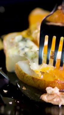 Üzerine bal, mavi peynir ve sağlıklı tatlı için ceviz konmuş yarım armut. Sağlıklı tatlılar için Gorgonzola peynirli fırında armut, fındık ve bal pişirmek. Peynirli ve fıstıklı armut