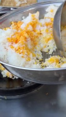 Şef, restoranın mutfağındaki ticari ocakta alevli ateşin üstünde tavada pilav kızartıyor. Yavaş çekimde 4K 'yı kapat. Yüksek kalite 