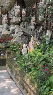 Bereketli yeşil tepeler ve uzaktaki kırsal manzarayla çevrili kayalık bir uçuruma tünemiş pagoda 'nın çarpıcı hava görüntüleri. Huzurlu manzara, Da Nang Vietnam 'ın doğal güzelliğini harmanlıyor. 04.12.2025