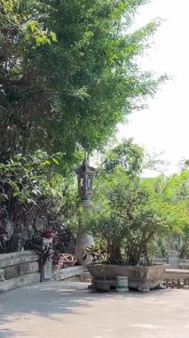 Bereketli yeşil tepeler ve uzaktaki kırsal manzarayla çevrili kayalık bir uçuruma tünemiş pagoda 'nın çarpıcı hava görüntüleri. Huzurlu sahne, doğal güzellikle kültürel mirası harmanlıyor..