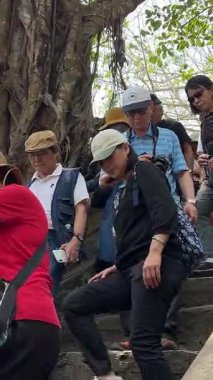 Turist gezileri farklı uluslara rehberlik eder. İnsanlar Mermer Dağ 'daki Budist tapınağını gezer. Buda tapınağının girişinin önünde. Da Nang, Vietnam 04.10.2025