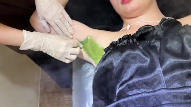 Güzellik uzmanının elleri kızların tenine şeker macunu sürüyor. Yüksek kalite 4k görüntü