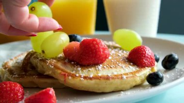 Yavaş çekimde meyveli güzel kreplerin üzerine akçaağaç şurubu dök. yeşil üzümler