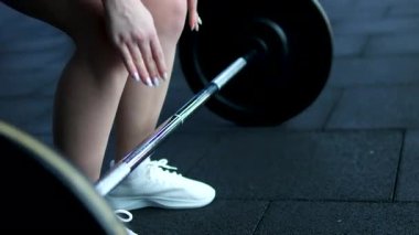 Kız antrenmanı bitirdi ve halter kaldırmayı bıraktı. Spor salonunda halter egzersizine hazırlanan kadın. Spor, egzersiz, güç, antrenman, atlet, ağırlık kaldırma. Yüksek kalite 4k