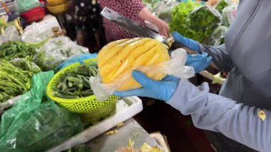 Hanoi, Vietnam sokaklarında ananası ustalıkla kesen bir kadının yakın çekim görüntüleri. Yüksek kalite 4k görüntü