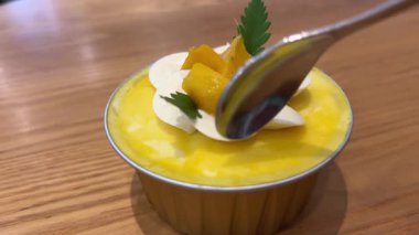 Mango soslu lezzetli mango dondurması ve berrak bardakta yumuşak vanilyalı dondurma. Kırmızı kaşıkla tadını çıkarın. Yüksek kalite 4k görüntü