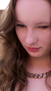 Parlak Giysili Kıvırcık Saçlı Kadın. Kıvırcık saçlı, parlak gümüş takım elbiseli, gülümseyen, aydınlık odalı neşeli kadının yakın çekimi. Yüksek kaliteli FullHD görüntüler