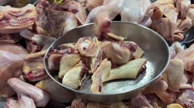 Süpermarketlerdeki işçilerin elleri, metal eldivenler giyerken çiğ tavuk parçaları koyarken yakın çekim çekimleri. Yüksek kalite 4k görüntü