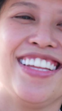 Vietnamlı kadın beyaz elbiseli beyaz şapkalı. Gülümseyen yüz ifadesi.