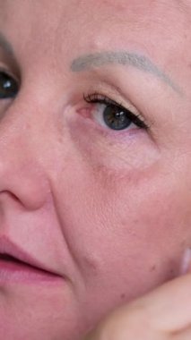 Kadın makyaj sanatçısının, daha önce uyguladığı nemlendirici genç kadının yüzüne pansiyon kremi sürerken güzel bir pozu. Cilt bakımı, kozmetik, makyaj, güzellik. temel uygula