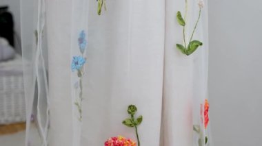 Pamuk kumaşın üzerinde güzel işlemeli çiçekler. Bir parça nakışa işlenmiş nakış ürünleri. İğne işi dekoratif dikiş ve tekstil sanatları el sanatıdır. İşlemeli çiçeklerin nasıl dikildiğini 