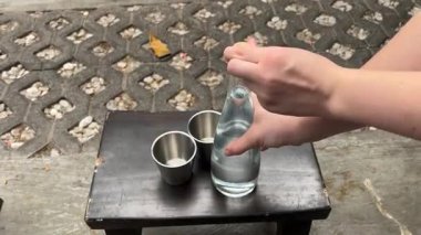 Kadınların elleri şişeden bardağa su dolduruyor, şeffaf cam içecek, ev sakinleri, ıslak içecek tutuyor. Yüksek kalite 4k görüntü