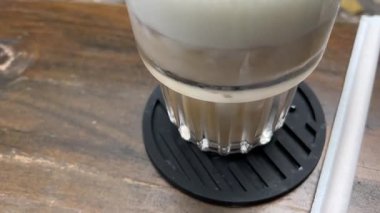 Kız eli kahve içer. Cappuccino 'yu ahşap masada tutan kızı yakın plan çek. Sabah kahvaltısı ve kahve arkaplanı. - Evet. Yüksek kalite 4k görüntü