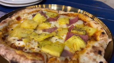 Hawaii pizzası ince çıtır ve jambonlu ananas ve ikili ya da ahşap tepside kalın esnek peynirli ikiz ya da doli tavuklu tavuk budu ızgaralı İtalyan yemeği.