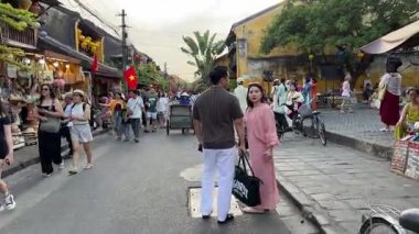 Turistler akşam kentinde dolanıp farklı milletlerden güzel sarı binalara bakıyorlar. Vietnam 'ın tarihi Hoi An şehrine gidiyorlar. 05.02.2025