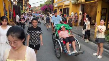 Vietnam 'da Hoi An şehrinde dolaşmak için bisiklet kiralayan bir aracın üzerindeki bir turistin görüntülerini izliyoruz. Hoi An Şehri Vietnam 05.02.2025