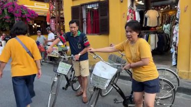 Turistler akşam kentinde dolanıp farklı milletlerden güzel sarı binalara bakıyorlar. Vietnam 'ın tarihi Hoi An şehrine gidiyorlar. 05.02.2025