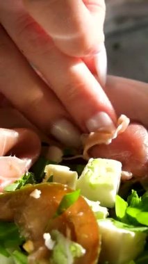 El salatayı hazırlar, elleri yakındır, ahşap bir kaseye taze bir salata atar. Yüksek kalite 4k görüntü