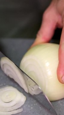 Şef kesme tahtasının üzerinde bıçakla soğan doğruyor, profesyonel mutfakta soğan doğrarken makroyu kapatıyor. Yüksek kalite 4k görüntü
