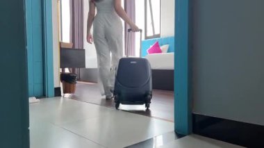 Otele bavulla girer. Seyahat çantasıyla geçen kendine güvenen beyaz bir kadınla otel odası. Güzel bayan turist yaz tatillerini tatil köyüne girerek geçiriyor. Turizm ve seyahat kavramı.