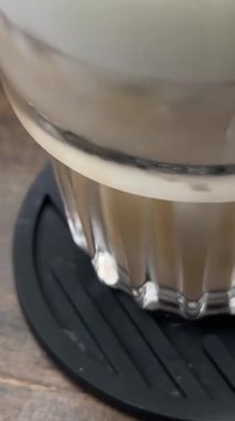 Kız eli kahve içer. Cappuccino 'yu ahşap masada tutan kızı yakın plan çek. Sabah kahvaltısı ve kahve arkaplanı. - Evet. Yüksek kalite 4k görüntü