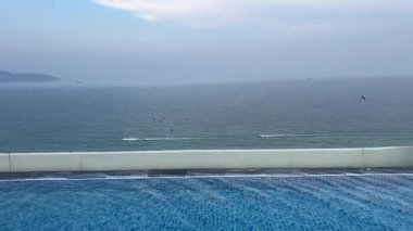 Tatilci Kadın Okyanus Manzaralı Sonsuzluk Havuzu 'nda Güzel Yüzüyor, Yavaş Hareketli. Dinlenme ve Tatil kavramı. Yüksek kalite 4k görüntü