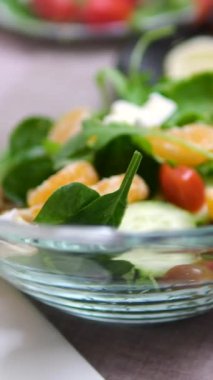 Sebze doğrayan sebze salatası vejetaryen kadın diğer taze meyvelerle çevrili beyaz kesme tahtasını dilimler ve sağlıklı meyve salatası yapmaya hazırdır. Yüksek kalite 4k görüntü